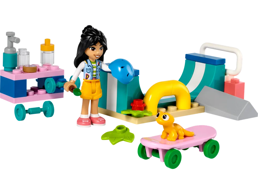 A LEGO Friends minifigure, Liann, with black hair and a vibrant top, stands next to a teal and white quarter-pipe skate ramp. A pink skateboard with a yellow gecko on it rests in the foreground. A pink mobile cart with clear bottles and a dumbbell is on the left.