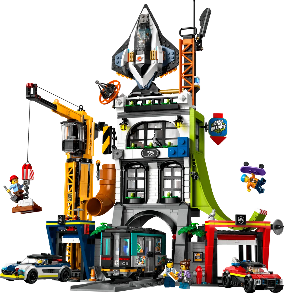 A full, front view of the LEGO City set 60473, a multi-story building featuring a crane, train, police car, fire truck, and spaceship on top, with various minifigures engaged in activities.