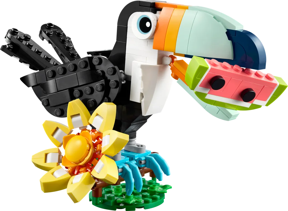 A bright, colorful LEGO Creator 3-in-1 Tropical Toucan with a watermelon in its beak, standing on a green base with a yellow and orange flower.