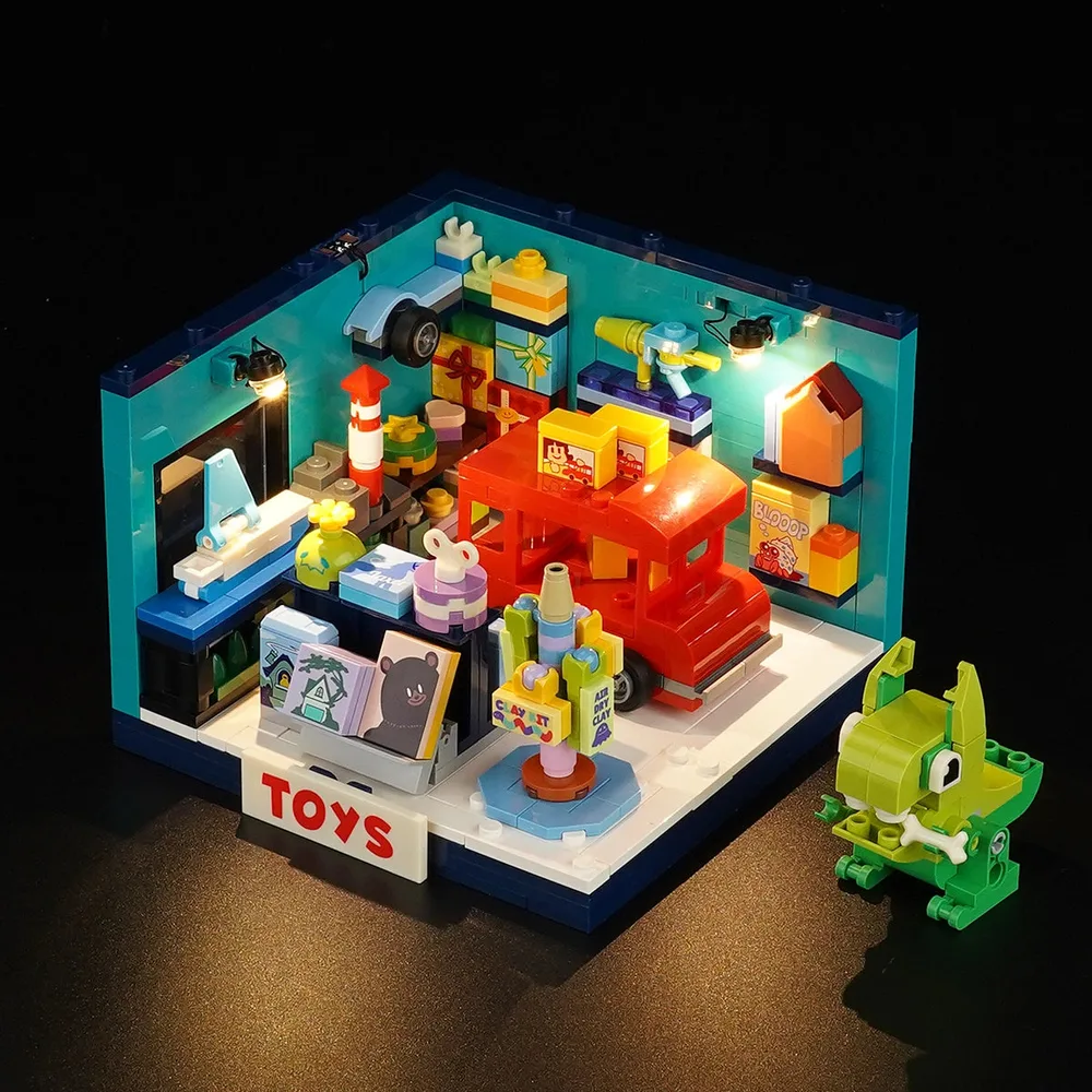 Lumibricks Toy Store (15020) lit up in a dark room, showcasing internal light points illuminating various toy displays. A green brick-built monster character sits to the right.