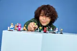 Child playing with Shrek LEGO Minifigures.