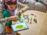 Child building LEGO with a tablet.