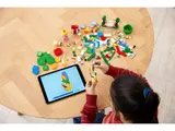 Child building LEGO with digital instructions.