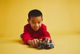 Child playing with LEGO race cars.