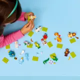 Child's hands assembling LEGO Minifigures.