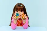 Child holding Peacock and Lion Minifigures.