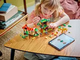 Child building tree with digital instructions.