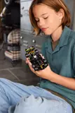 Child closely examining LEGO APXGP car.