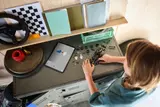 Child building LEGO APXGP car with tablet.