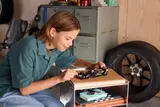 Child playing with LEGO APXGP race car.