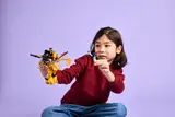Child playing with mech and minifigure.