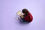 Child building with tablet.