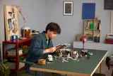 Builder assembling LEGO Arkham Asylum.