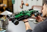 Man holding completed F1® car, smiling.