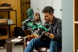 Man holding completed F1® car, smiling.