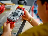 Child holding LEGO Audi S1 e-tron quattro.