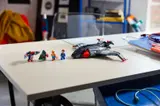 Assembled Quinjet with all four minifigures on a table.