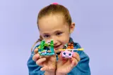 Child happily holding up the LEGO Axolotl Adventure Boat set.