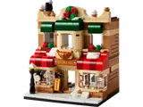LEGO 40696 Bakery micro-build front view, featuring tan facade, red awnings, a golden croissant, and a rooftop wreath.