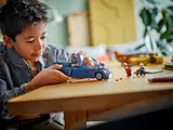 Child playing with LEGO Batmobile.