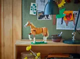 LEGO horse model on a wooden shelf.