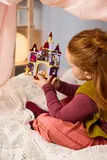 Child holding LEGO castle.