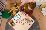Child building LEGO castle with tablet.