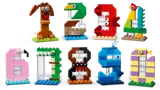 Ten diverse LEGO animal numbers (0-9) on a white surface.