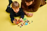 Playing with LEGO Bluey set on floor.