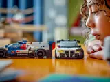 Child inspecting LEGO BMW race cars.