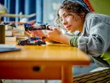 Child playing with LEGO BMW race cars.