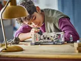 Boy playing with LEGO Star Wars Tantive IV set, adjusting minifigures.