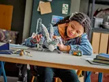 Person playing with Buckbeak model.