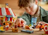 Child's hands playing with LEGO Buggy's Circus Tent.