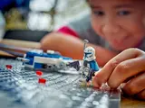 Child places Captain Rex minifigure.