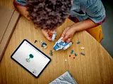 Overhead view of child building with tablet.