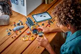 Child building LEGO cement mixer with tablet.