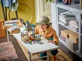 Child playing with LEGO Train Station.