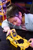 Girl opens Corvette frunk.