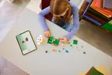 Girl building LEGO set with digital instructions.