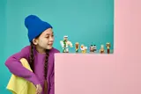 Child playfully watching LEGO figures.