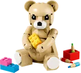 Tan LEGO teddy bear holding a yellow brick.