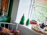 Two different size LEGO Christmas trees on a sill.