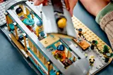 Child placing roof on LEGO streetcar.