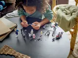 Child building a LEGO Star Wars blaster.