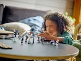 Child winking while playing with LEGO blaster.