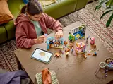 Girl building LEGO Friends Comic Book and Game Store.