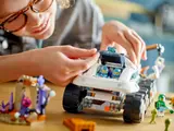 Child placing minifigure in rover cockpit.