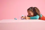 Girl laughing with LEGO set.