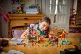 Girl building LEGO Hot Springs Cabin.